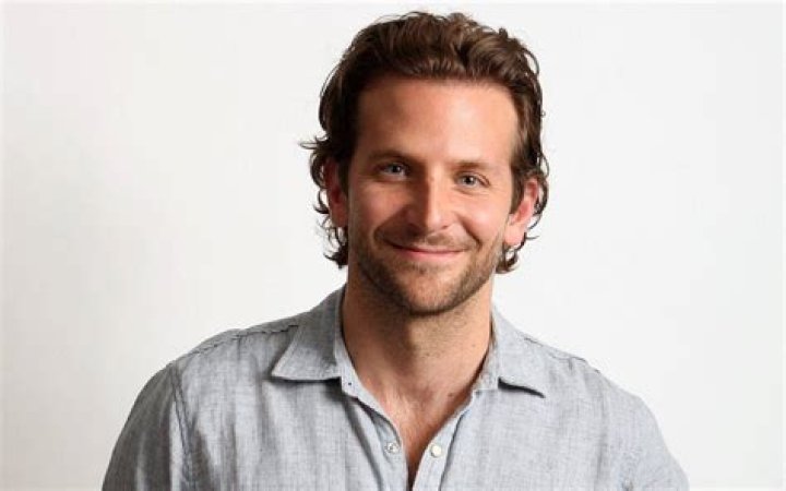 Bradley Cooper is smiling and posing for the cameras.