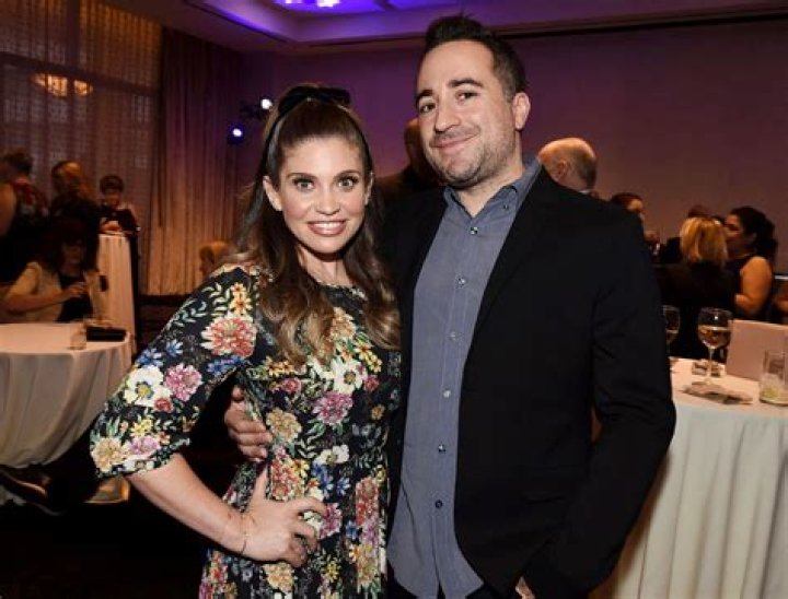 Danielle Fishel and Jensen Karp are holding up the paper that says if these lips could talk.