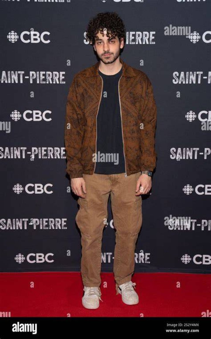 Ehren Kassam posing by wearing t-shit and a black vest.