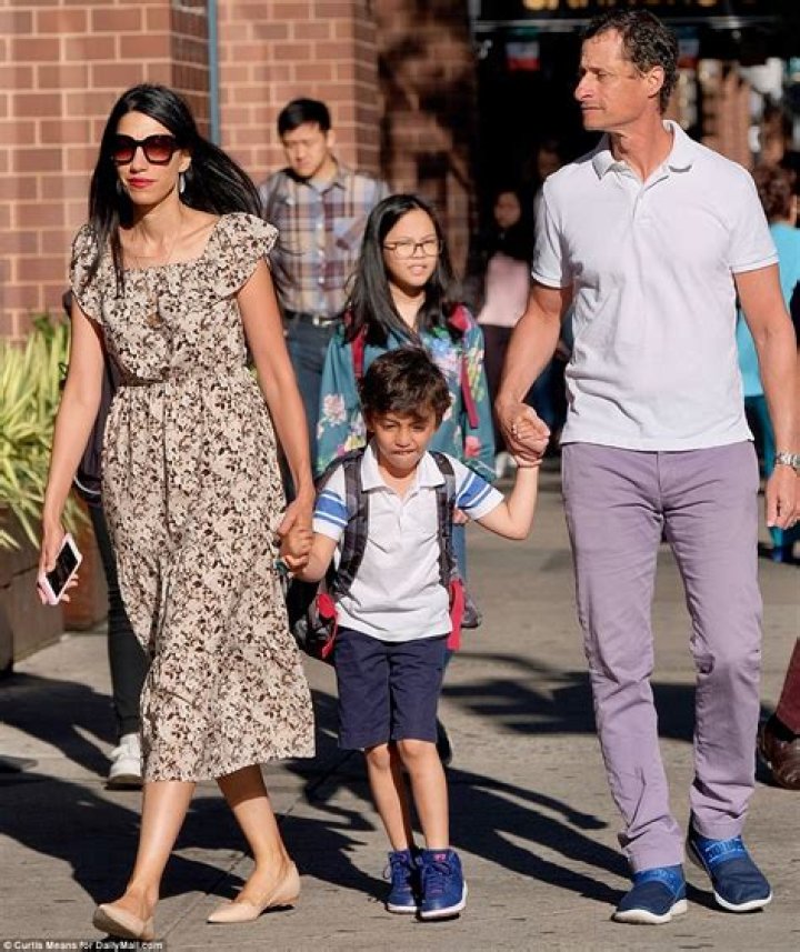 Huma Abedin is holding Jordan Zain Weiner's hand as they are walking.