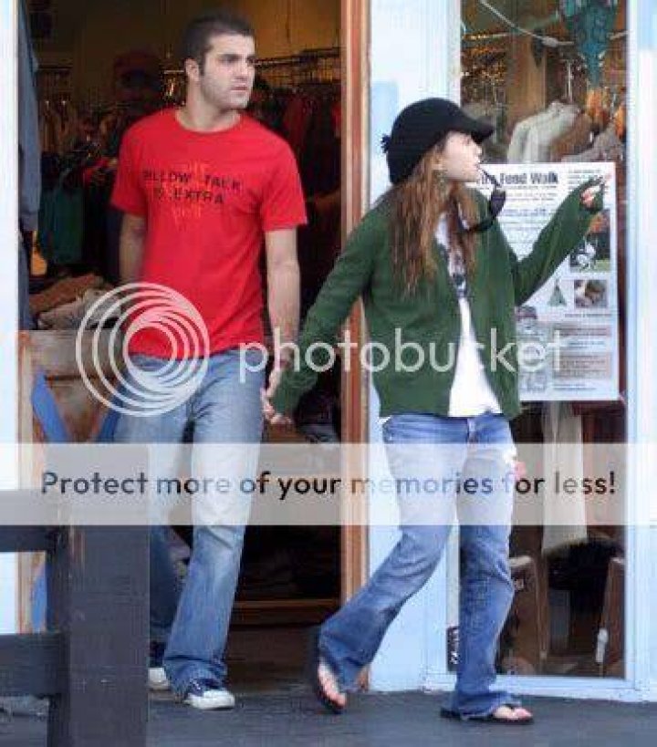 Katzenberg and Olsen leaving a store. Olsen is leading Katzenberg by the hand
