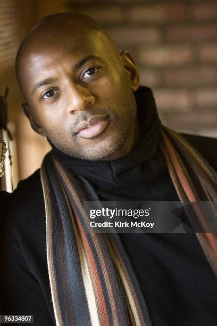 Romany Malco posing for his Instagram feed by wearing orange vest.
