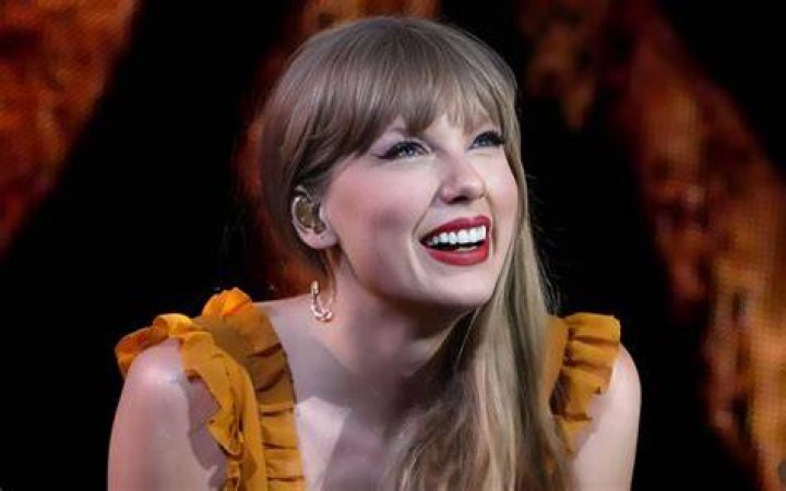 Taylor Swift looking happy holding a cat in Me! Music video