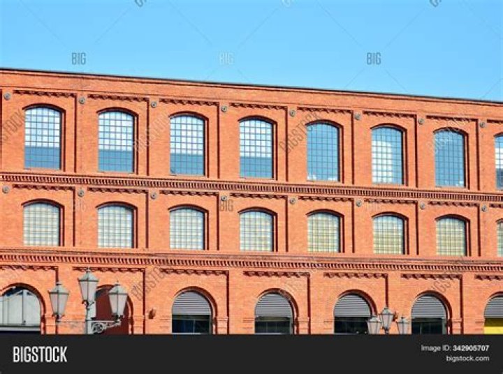 The large building is red in color and has a lot of windows.