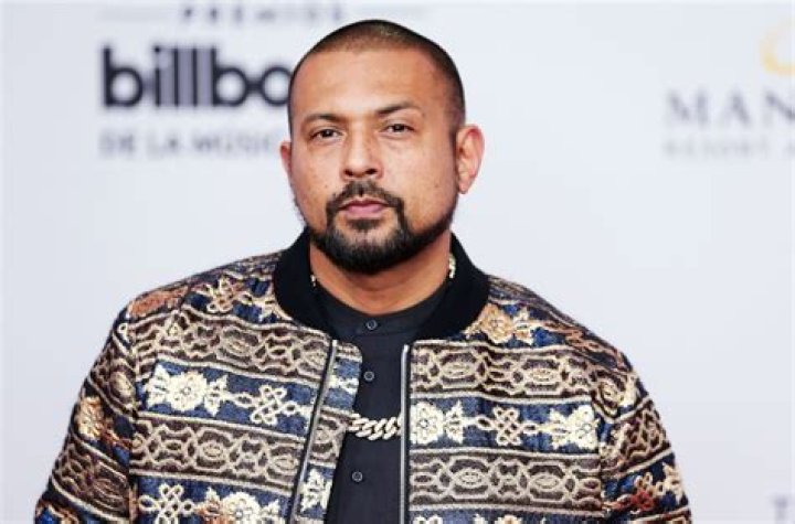 The pic shows Jigzagula wearing a black shirt with flower design on it.